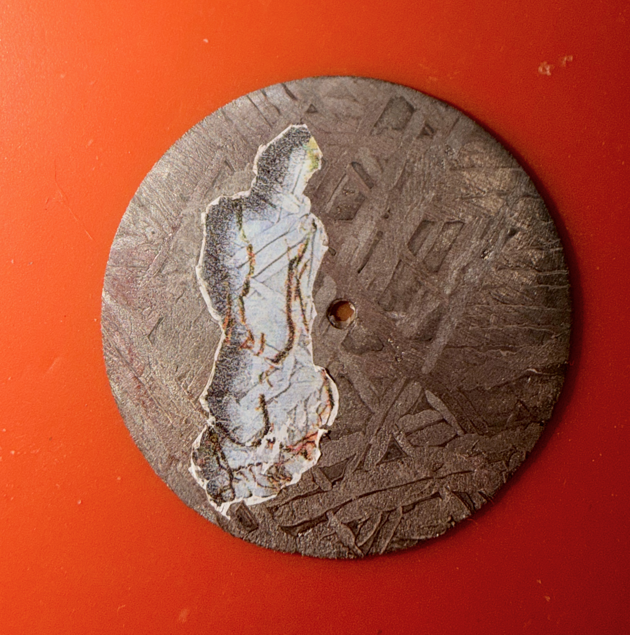 A figure transferred onto an etched meteorite dial