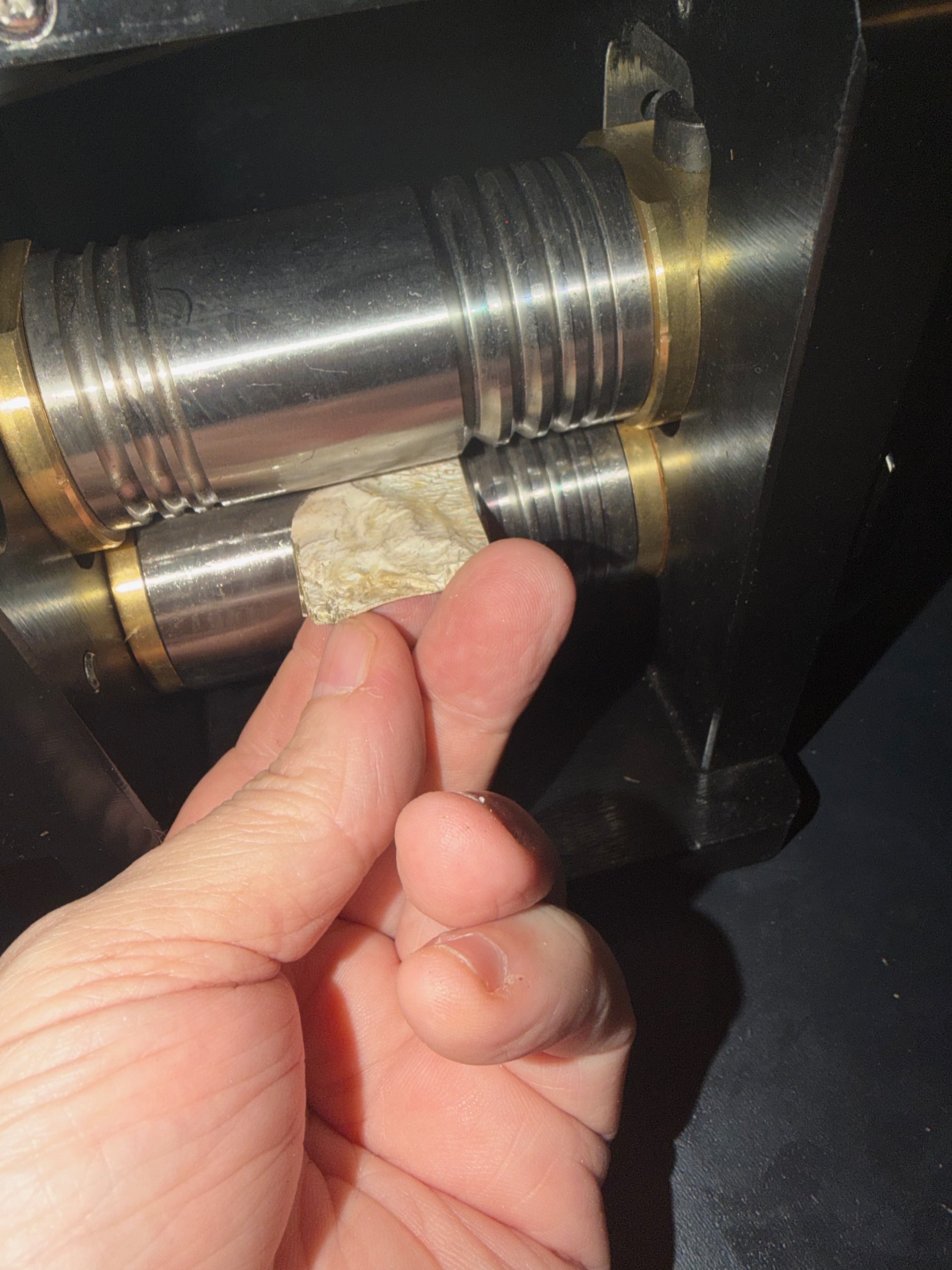 A sheet of his silver going through the rolling mill