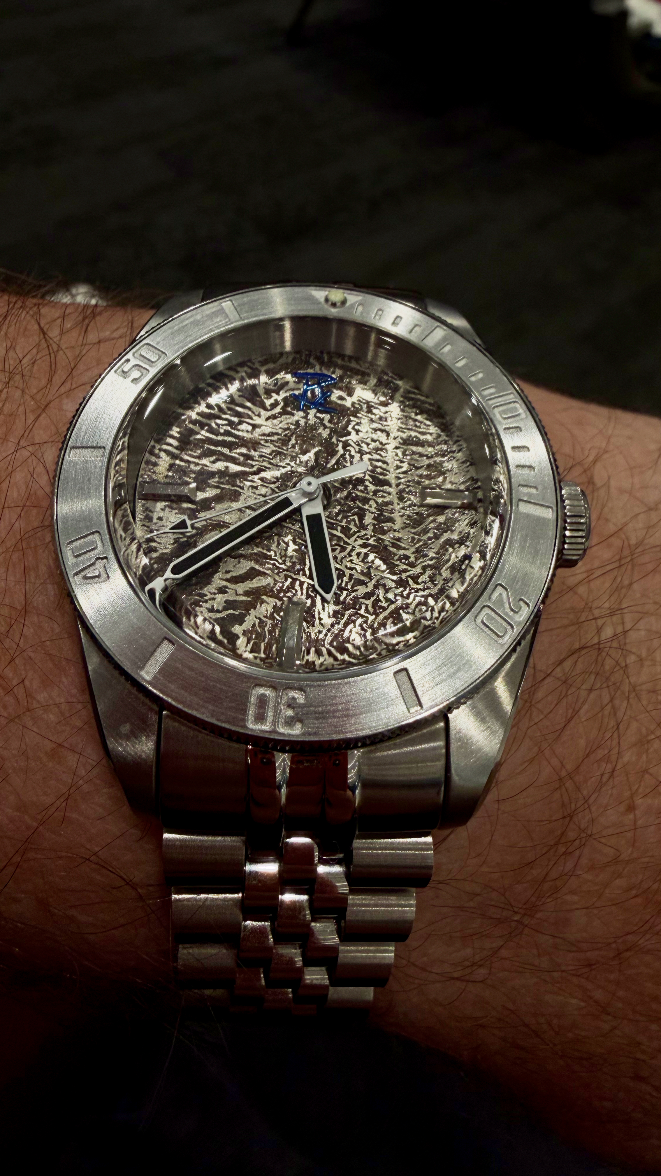 The bare reticulated silver diver on its jubilee bracelet, close