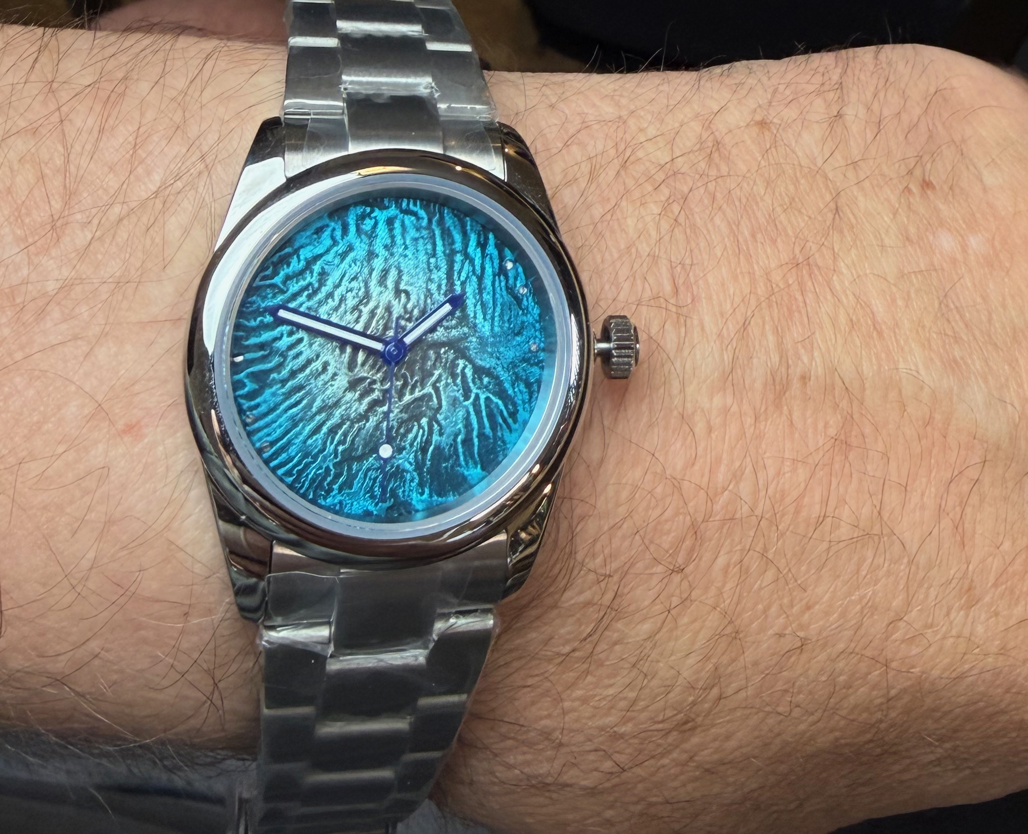 A turquoise enamelled reticulated dial on a steel bracelet